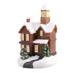 Model of a train station with a clock tower covered in snow on a white background