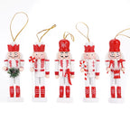 Set of five Nutcracker Christmas ornaments in red and white on a white background