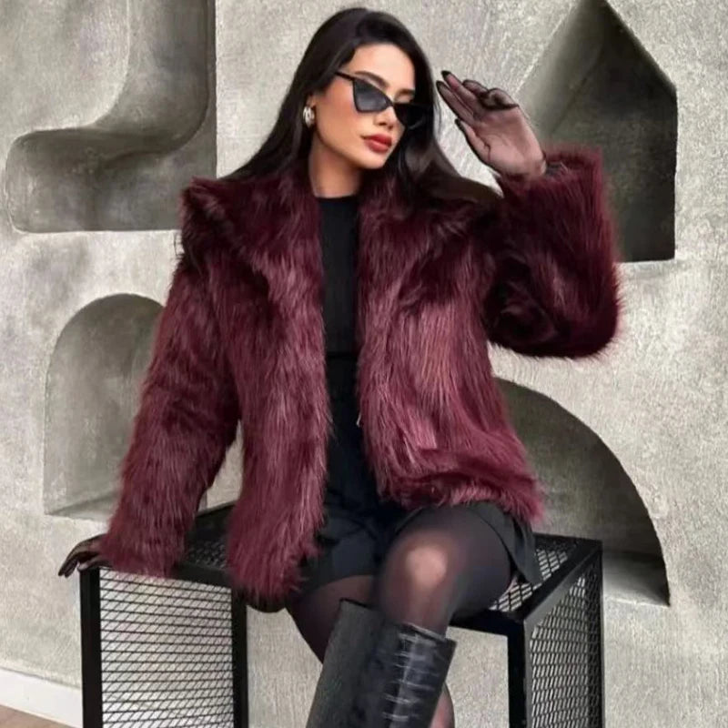 Woman wearing a purple fur coat and black sunglasses against a textured wall.