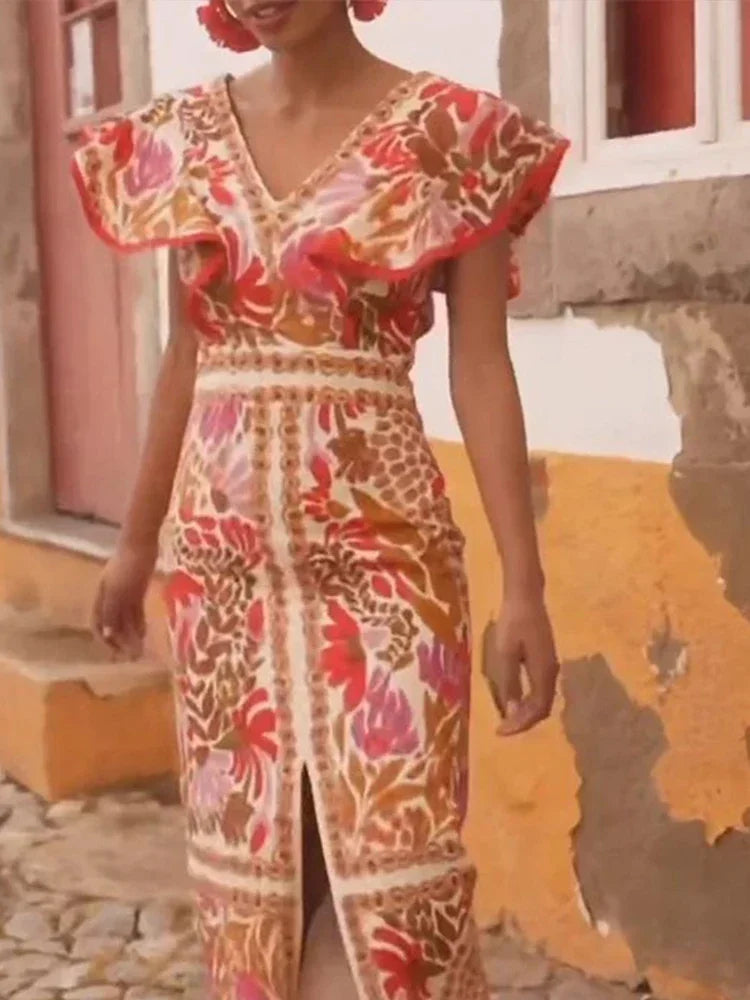 Woman wearing a colorful floral dress standing in front of a building.