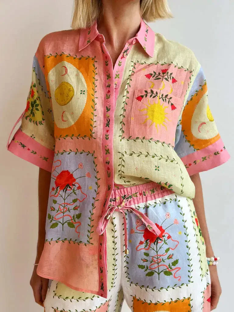 Colorful embroidered shirt and pants set with floral and geometric patterns on a plain background