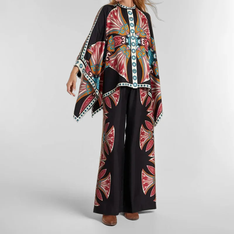 Person wearing a black outfit with colorful floral patterns on a plain background