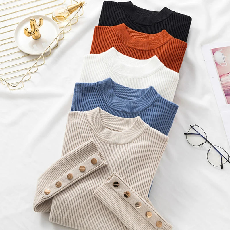 Four sweaters in black, orange, blue, and beige with button details on a white surface.