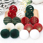 Decorative balls in red, green, and white on a snowy surface with Christmas decorations.