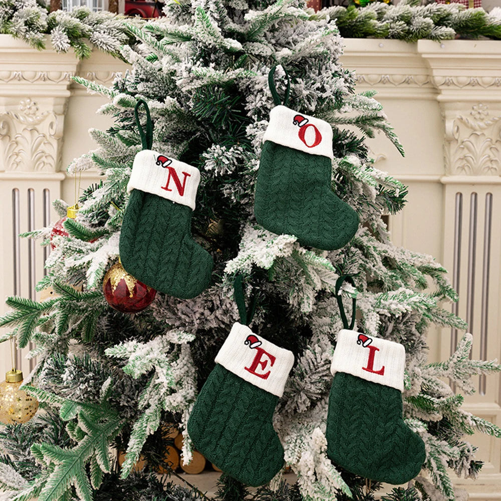 Green Christmas stockings with letters attached to a decorated tree.