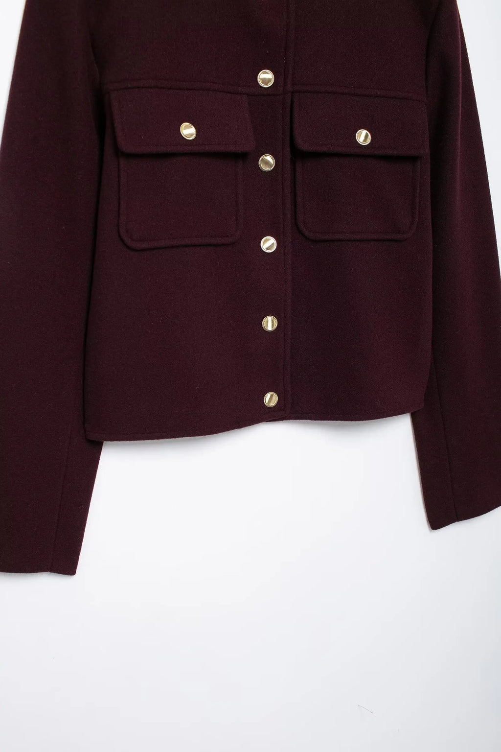Close-up of a burgundy jacket with gold buttons on a white background