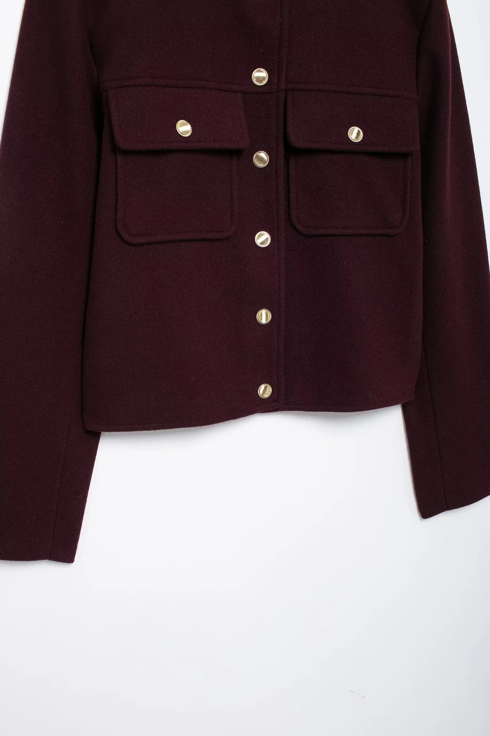 Close-up of a burgundy jacket with gold buttons on a white background