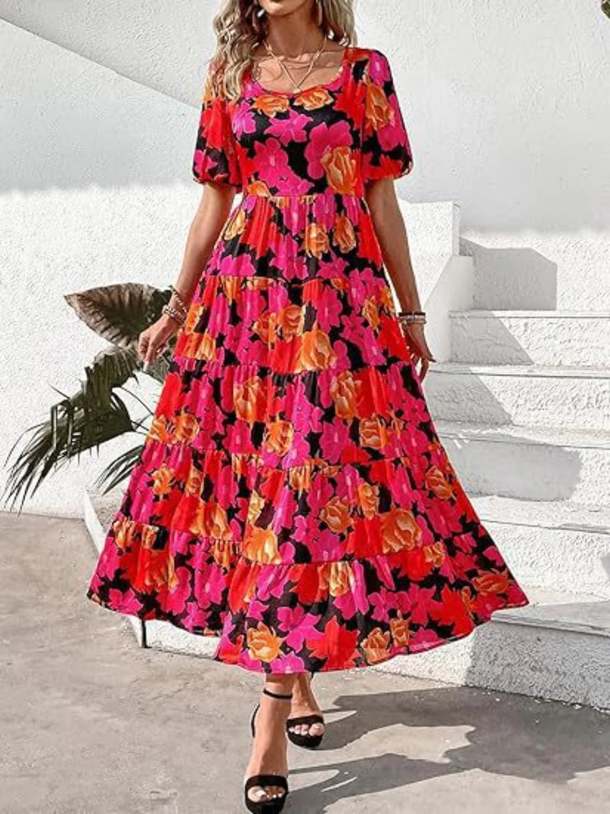 Woman wearing a colorful floral dress standing on a white background