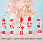 Set of nutcracker ornaments with red hats and white bodies in front of a decorated Christmas tree.