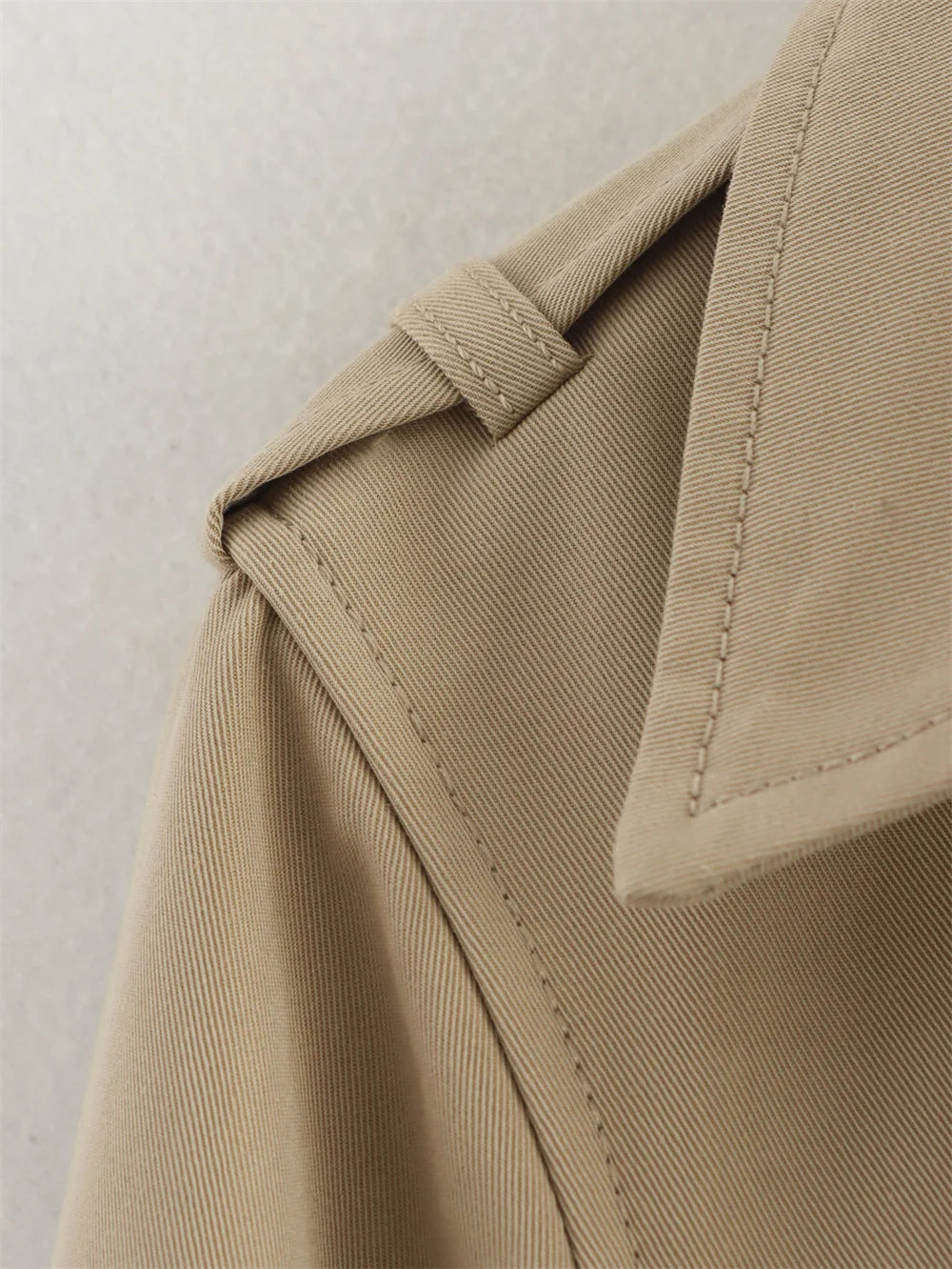 Close-up of beige fabric with a focus on stitching detail.