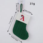 Green knitted Christmas stocking with white cuff featuring a red letter 'A', showing measurements and weight on a light gray background.