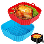 Silicone baking trays in red, blue, and black with food items on a white background