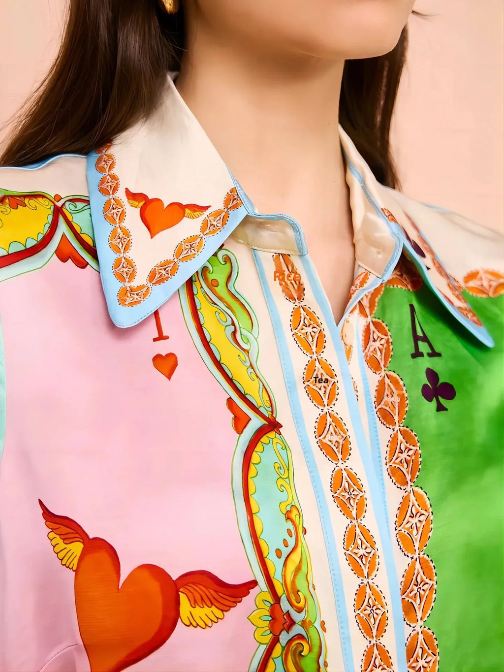 Colorful patterned shirt with heart and card suit designs on a blurred background