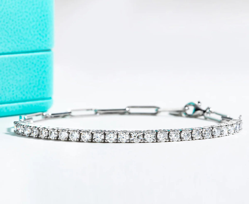 Silver bracelet with 3mm moissanite stones on a light blue background