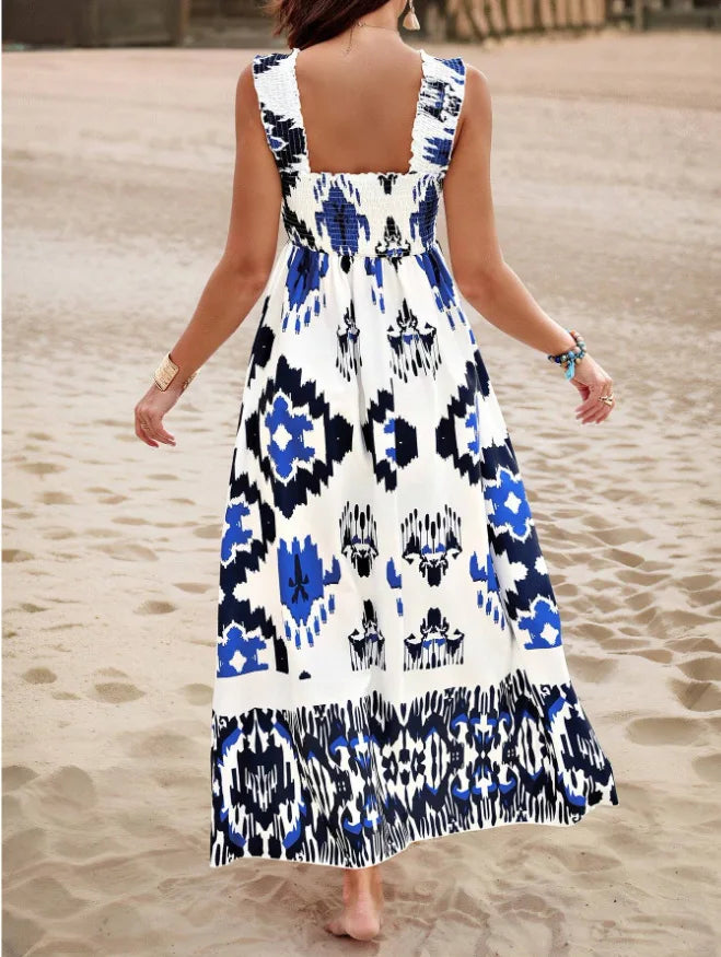 Woman wearing a sleeveless dress with blue and white pattern on a sandy background