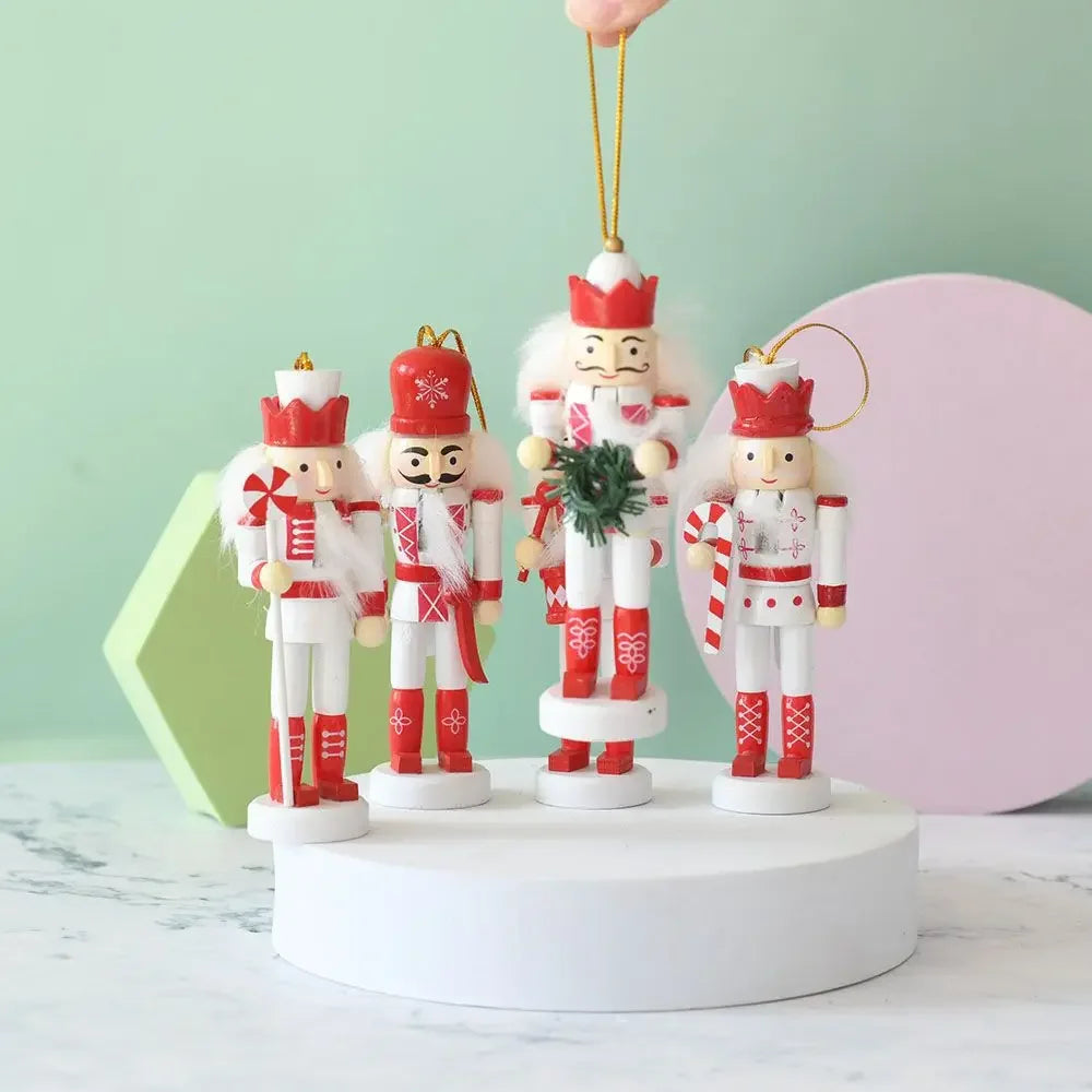 Set of four nutcracker ornaments on a white platform with a light green background