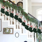 Decorative stockings with Christmas-themed designs hanging on a staircase.