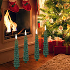 Decorative Christmas tree candles in front of a fireplace with stockings and a tree.