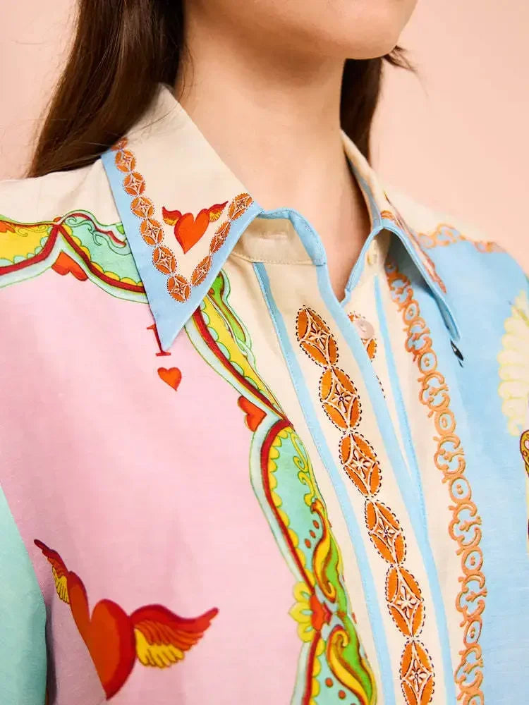 Close-up of a colorful shirt with a patterned collar and heart designs.