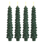 Four green tree-shaped candles with lit wicks on a white background