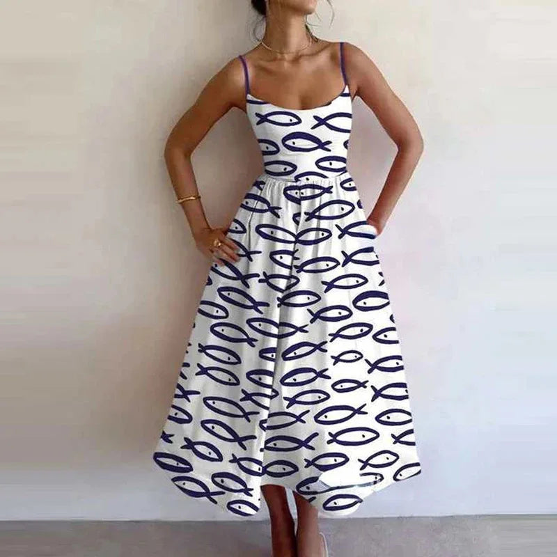 Woman wearing a white dress with black fish pattern against a plain background