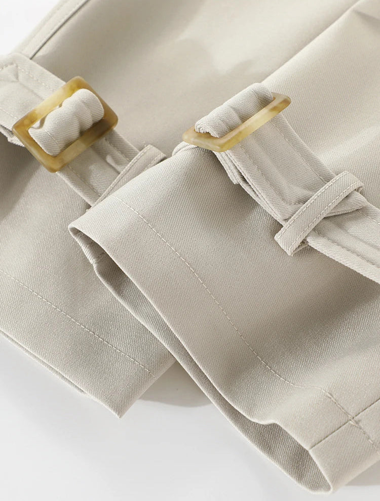 Close-up of beige fabric with wooden buckles on a white background