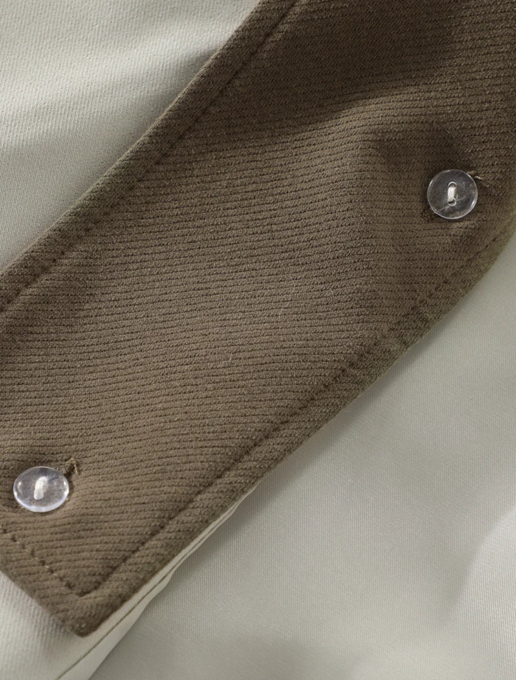 Close-up of a textured fabric edge with metal buttons on a beige background