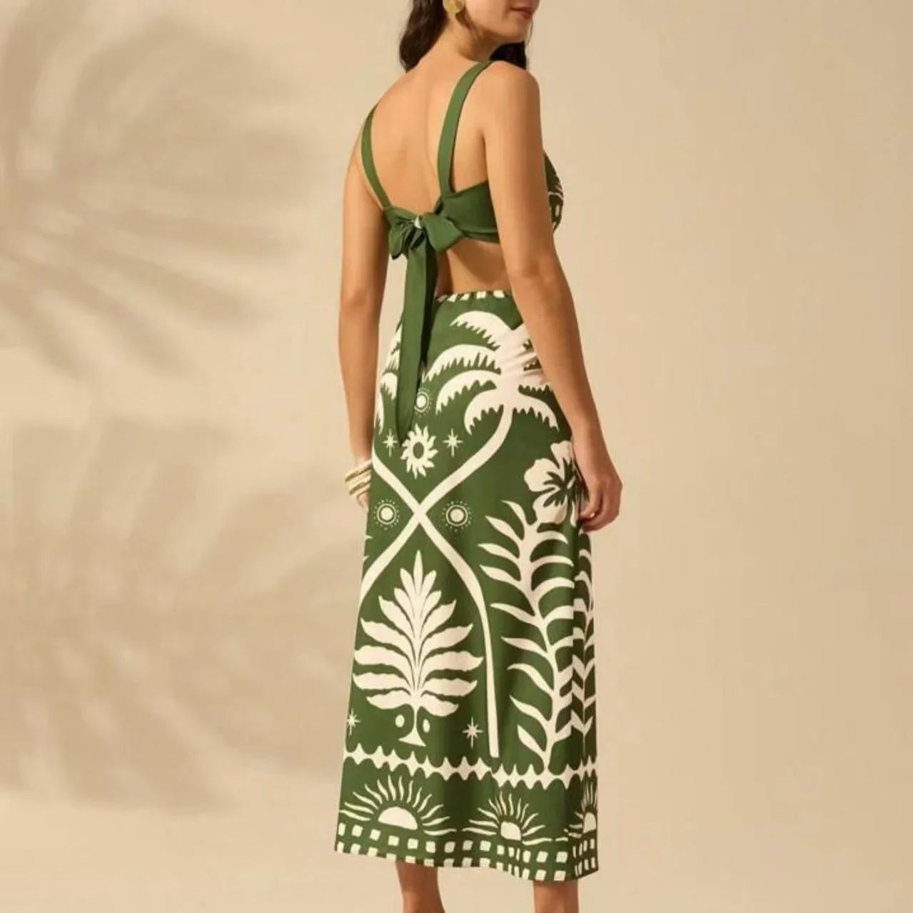 Woman wearing a green and white patterned dress with a beige background